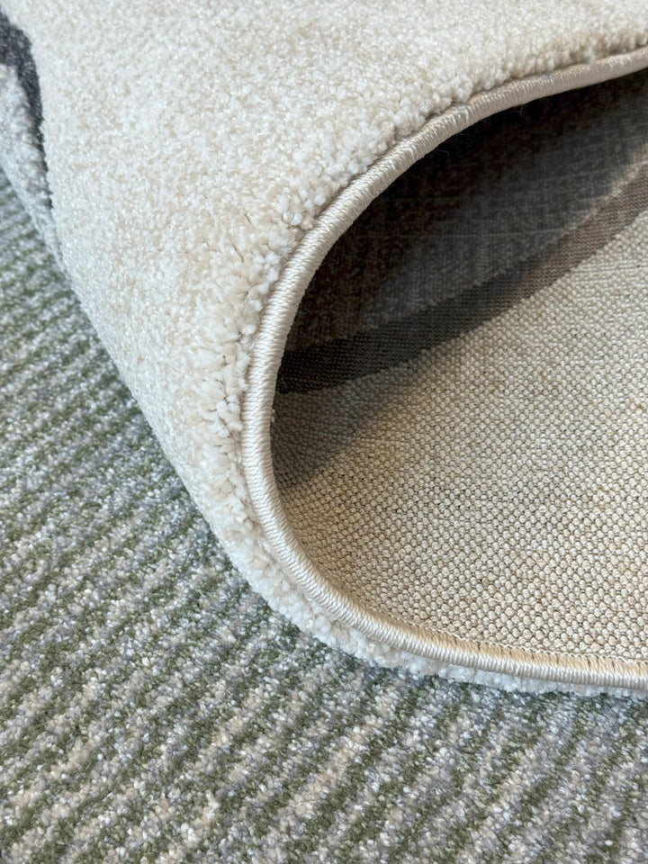 Neutral abstract rug design with textured shapes in earthy tones