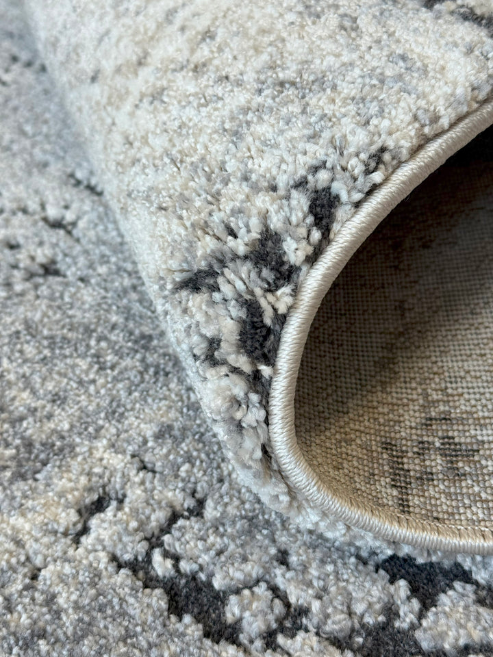 Close-up of a textured rug with a pattern on a sandy surface