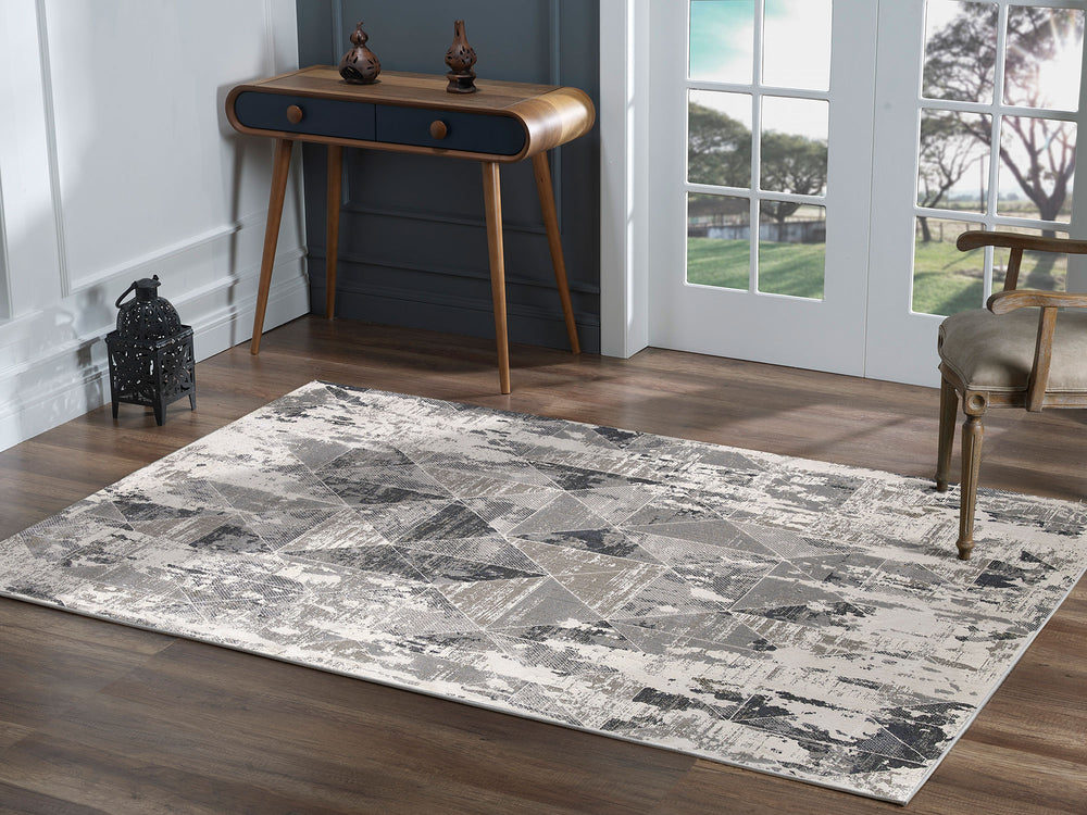 A contemporary area rug with a geometric pattern in gray, black, and ivory tones.