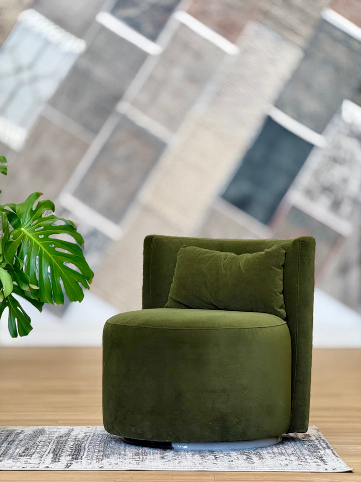 Green swivel chair made of soft suede fabric, featuring a modern design with a comfortable, cushioned seat and backrest.