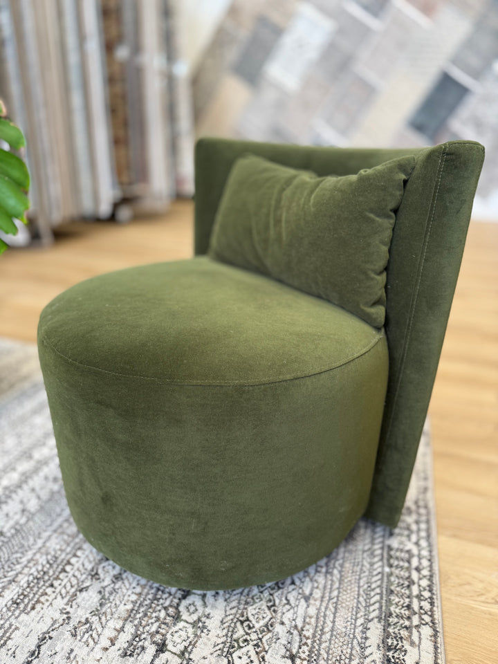 Green swivel chair made of soft suede fabric, featuring a modern design with a comfortable, cushioned seat and backrest.