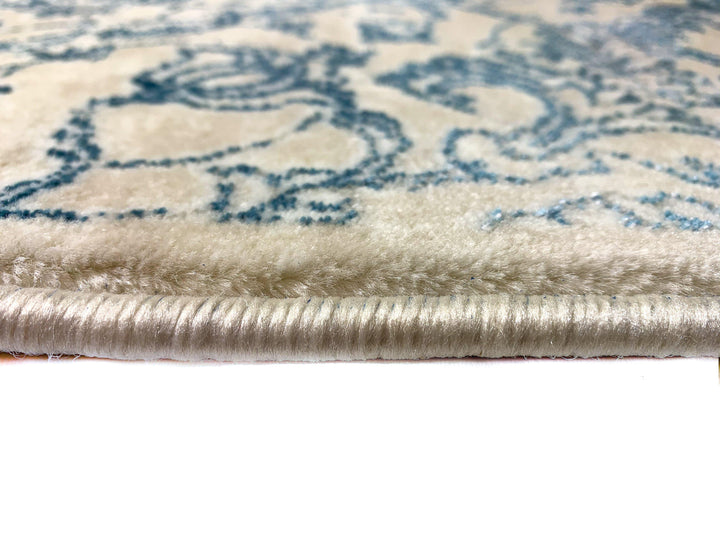 Airmont 118 Rug side view light blue thin damask pattern cream background