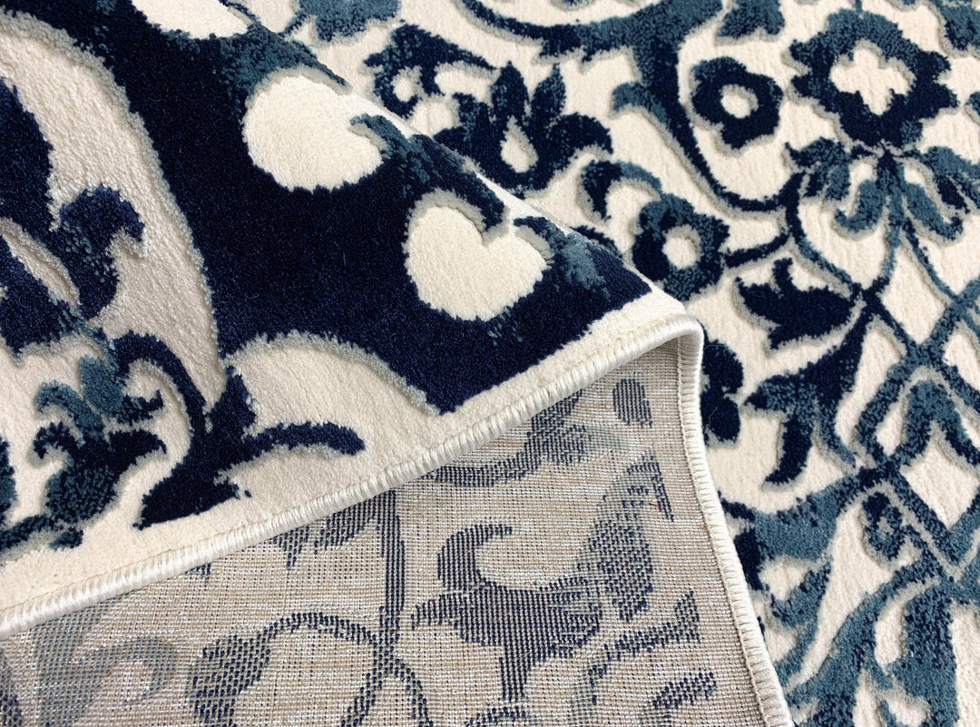 Airmont 145 rug fold view bold blue medallion pattern cream background
