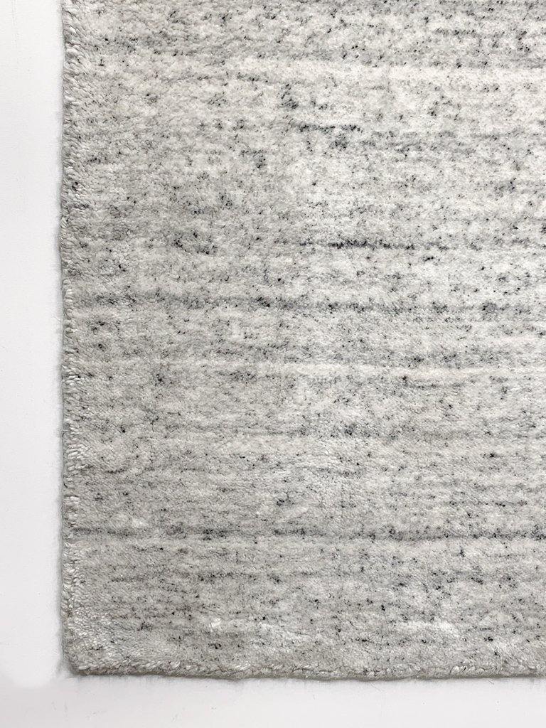 Akita Ivory Flek rug corner view white base dark grey flek horizontal texture