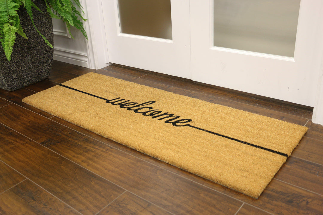 Coconut fibre welcome mat with "welcome" written in cursive 